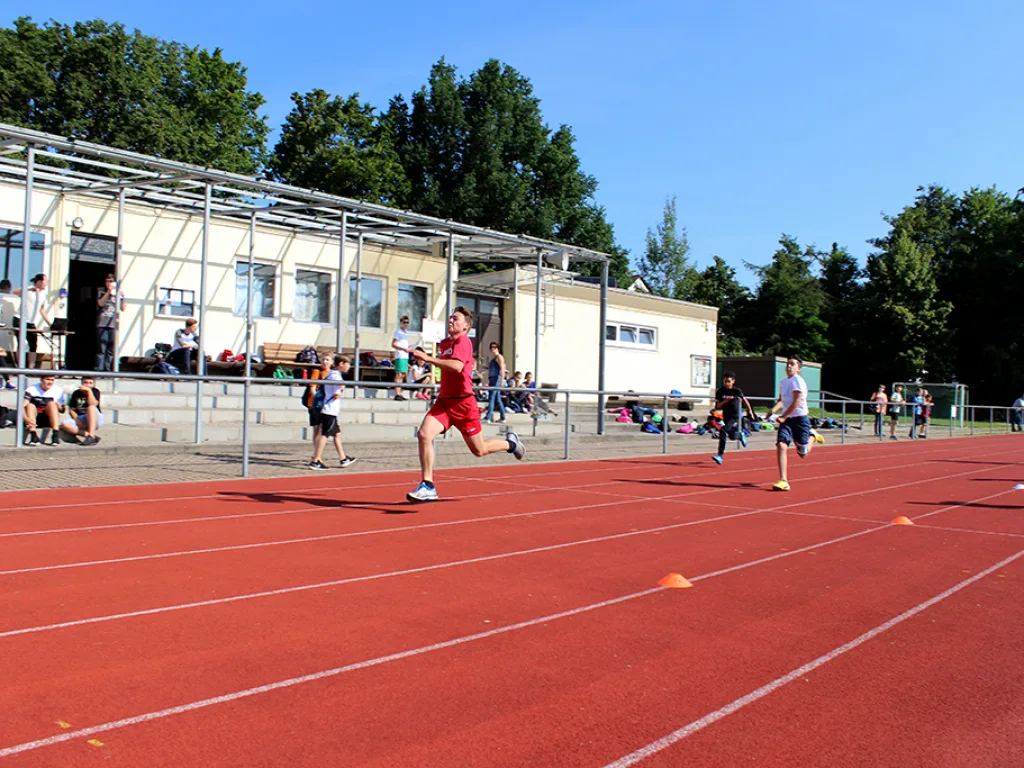 Läufer auf der Bahn vor dem Sportheim.